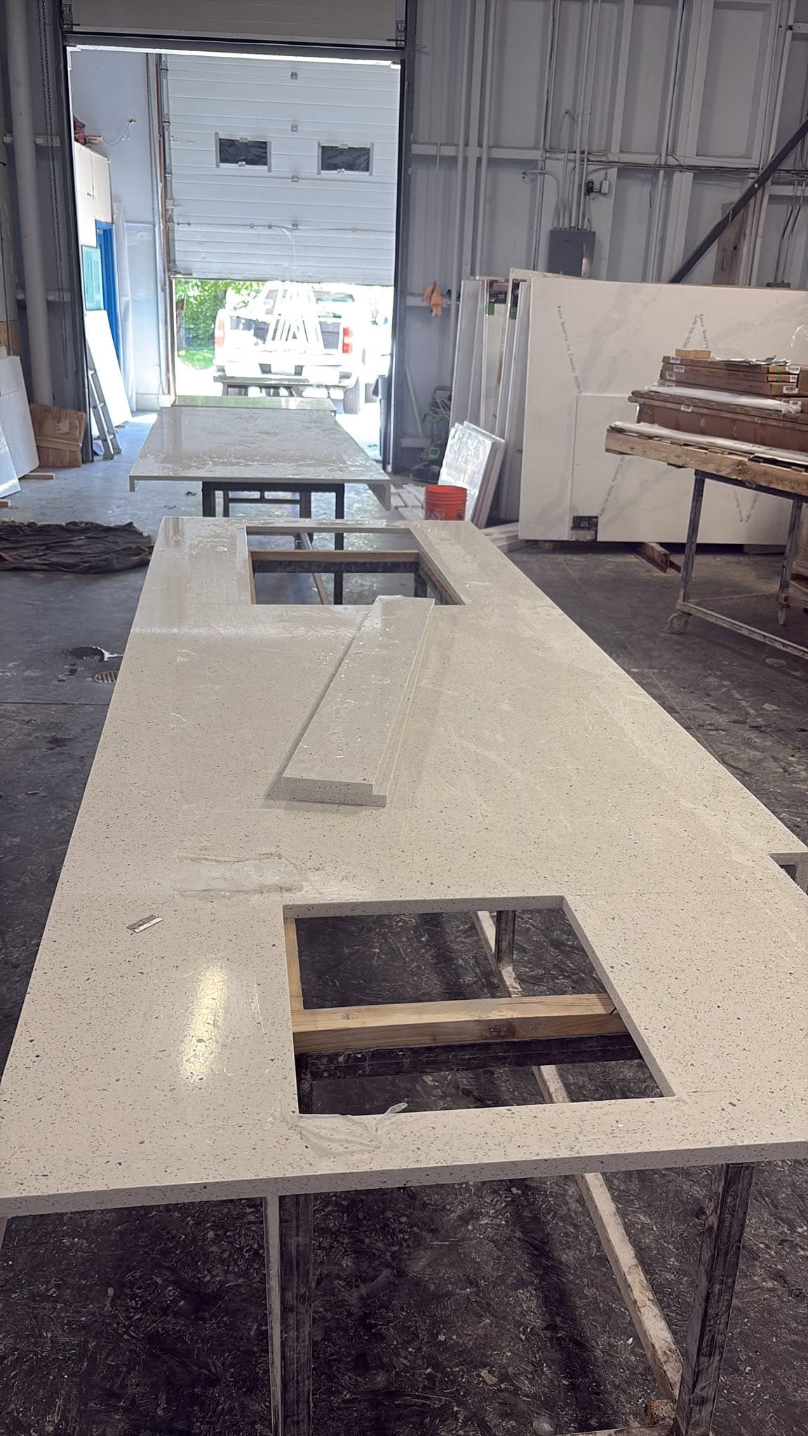 Fabricated quartz counter run with machined cutouts, ready to install