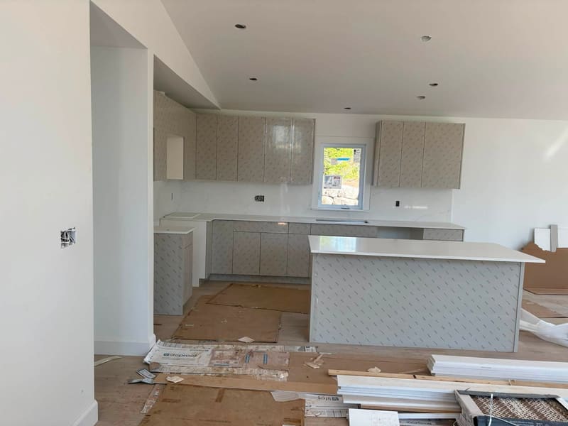Open-plan kitchen mid-install with quartz counters going in