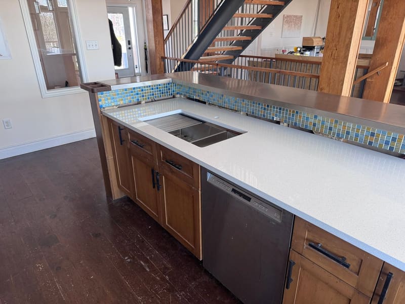 Quartz island with open shelving underneath in a bright room
