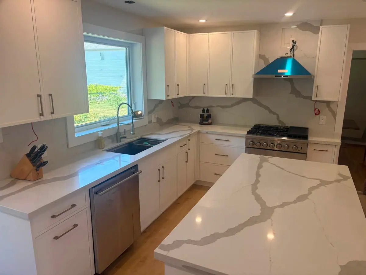 White quartz kitchen with a full-height veined backsplash