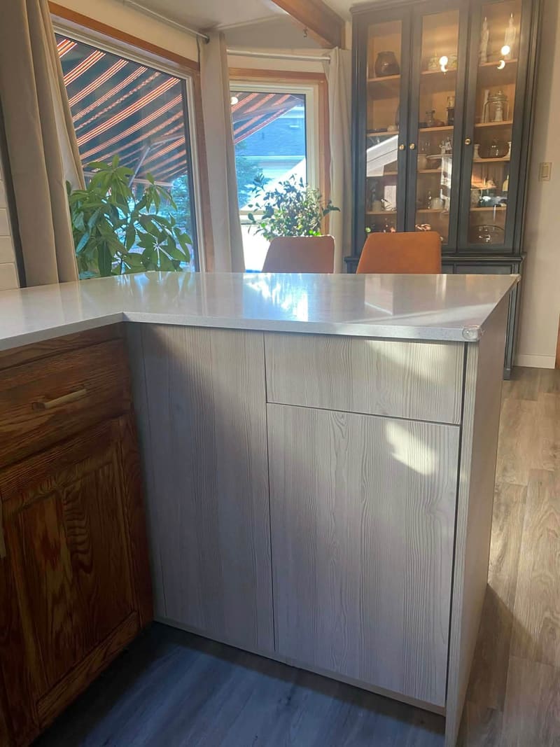 Quartz peninsula counter over grey shaker cabinetry