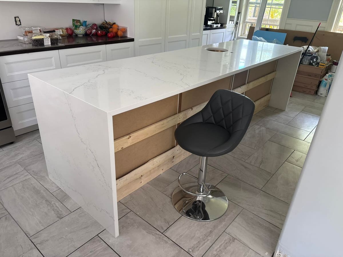 White stone bar counter with a waterfall return and stool